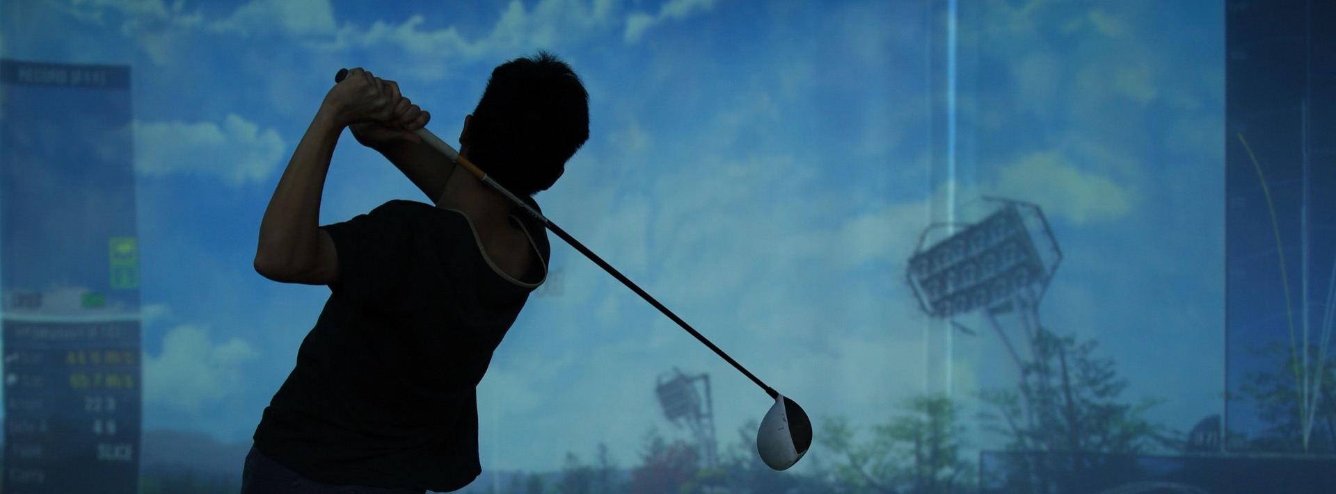 Golfer swinging in an indoor simulator